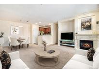 Cozy living room featuring a fireplace, comfortable seating, and an open floor plan to the kitchen and dining area at 8039 Lee Dr # 2, Arvada, CO 80005