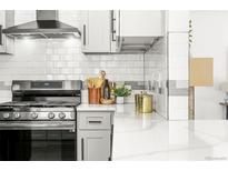 Bright kitchen featuring stainless steel appliances, white cabinetry, and white subway tile backsplash at 11710 Spruce Canyon Cir, Golden, CO 80403