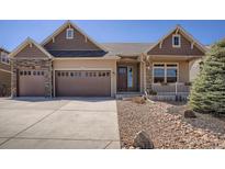 Charming home featuring a two-car garage, stone accents, covered front porch, and well-maintained landscaping at 1815 Avery Way, Castle Rock, CO 80109