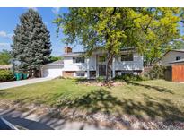 Charming two-story home with a well-manicured lawn and mature trees at 848 S 13Th Ave, Brighton, CO 80601