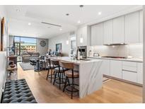 Open-concept kitchen with island, modern appliances, and sleek cabinets flows into the living area at 1901 Wazee St # 504, Denver, CO 80202