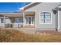 Inviting front entrance to this grey home, with covered porch and beautiful front door at 51 W 6Th Pl, Byers, CO 80103