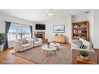 Bright living room featuring large windows, fireplace, hardwood floors, and stylish, comfortable seating at 51 W 6Th Pl, Byers, CO 80103