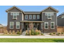 Modern two-story townhome with gray siding and brick accents at 14063 Jackson St, Thornton, CO 80602