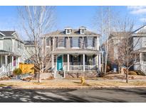 Charming two-story home featuring a welcoming front porch with blue door, shutters, and well-maintained landscaping at 3538 Akron Ct, Denver, CO 80238