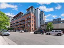 Street view of a brick building with multiple levels and balconies at 2960 Inca St # 112, Denver, CO 80202