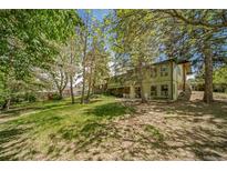 Spacious backyard featuring mature trees and a patio area, perfect for outdoor relaxation and entertaining at 13955 W 26Th Ave, Golden, CO 80401