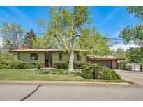 Charming home with green exterior, mature trees, and well-maintained lawn at 13955 W 26Th Ave, Golden, CO 80401