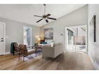 Bright living room featuring hardwood floors, neutral walls, ceiling fan, and sliding glass doors to the backyard at 19644 E Girard Dr, Aurora, CO 80013