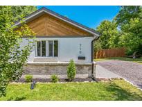 Charming home exterior featuring a manicured lawn, gray brick and white stucco and tasteful landscaping at 710 Raleigh St, Denver, CO 80204