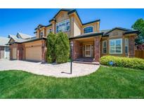 Attractive two-story home with brick accents, lush landscaping, and a manicured front lawn; a welcoming and well-maintained exterior at 5416 S Hannibal Ct, Centennial, CO 80015
