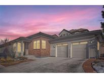 Charming home exterior with brick accents and a spacious two-car garage, perfect for suburban living at 10526 Fairhurst Way, Highlands Ranch, CO 80126