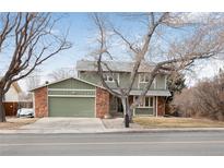 Two-story home with a green garage door, stone accents, and mature trees at 1331 Alpine St, Longmont, CO 80504
