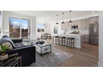Bright, open-concept living space with hardwood floors, modern decor, and sliding glass doors to a balcony at 4650 W 9Th Ave, Denver, CO 80204