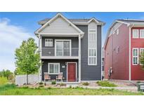 Charming two-story home with a cozy front porch and a well-manicured lawn at 18645 E 54Th Pl, Denver, CO 80249