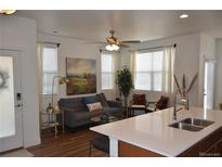 Bright living room featuring hardwood floors, comfortable seating, and stylish decor at 9756 Ash Ln, Thornton, CO 80229