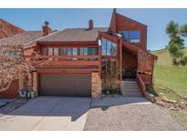 Inviting two-story home featuring a two-car garage, balcony, and stone accents at 4484 Juniper Ct, Larkspur, CO 80118