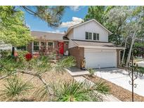 Charming brick home featuring a two-car garage, landscaped front yard, and a vibrant red front door at 6327 S Emporia Cir, Englewood, CO 80111