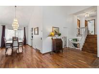 Bright open-concept living and dining area with hardwood floors, white walls, and modern light fixture at 6327 S Emporia Cir, Englewood, CO 80111