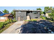Modern two-story home with a sleek gray exterior, updated landscaping, and a private front yard at 220 S Raleigh St, Denver, CO 80219