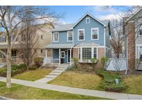 Charming blue two-story home with a welcoming front porch and well-maintained lawn at 7860 E Ellsworth Ave, Denver, CO 80230