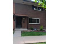 Traditional brick home with a covered front entry and manicured lawn offers classic charm at 12640 W Virginia Ave, Lakewood, CO 80228