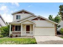 Two-story house with a beige exterior, attached garage, and front porch at 470 Grey Swallow St, Brighton, CO 80601