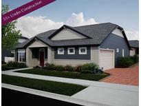 Charming single-story home with blue siding, stone accents, manicured lawn and brick driveway. 55+ community at 21895 E 51St St, Aurora, CO 80019