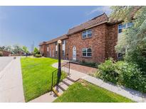 Charming brick townhome featuring a well-manicured lawn and inviting entryway at 3608 W Radcliff Ave, Denver, CO 80236