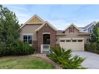 Charming two-story home featuring a well-manicured lawn, brick accents, and an attached two-car garage at 17223 W 84Th Dr, Arvada, CO 80007