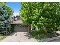 Charming home boasts a two-car garage with basketball hoop and mature landscaping creating a welcoming curb appeal at 12 Long Spur, Littleton, CO 80127