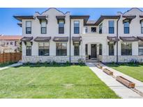 Inviting exterior of a multi-story home with a well-manicured lawn, stone accents, and attractive architectural details at 1640 Winona Ct, Denver, CO 80204