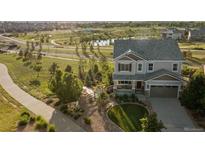 Charming two-story home with manicured lawn, complemented by lush greenery and a tranquil pond view at 3741 Harvard Pl, Broomfield, CO 80023