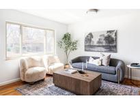 Cozy living room with bright window, featuring modern furniture and decor with hardwood floors and decorative rug at 6580 Independence Way, Arvada, CO 80004