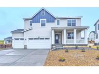 Charming two-story home featuring a three-car garage, front porch, and landscaped yard at 39857 Floyd St, Elizabeth, CO 80107