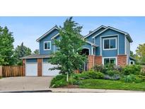 Charming two-story home with blue siding, brick accents, and a well-manicured lawn, offering great curb appeal at 19113 W 60Th Ln, Golden, CO 80403
