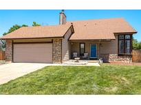 Charming single-story home featuring a well-maintained lawn, inviting entrance and an attached garage with stone accents at 750 S Dearborn Ct, Aurora, CO 80012