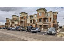 A multi-story condo building with balconies and parking in front showcases a modern architectural design at 4100 Albion St # 303, Denver, CO 80216