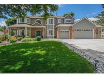 Charming two-story home boasts a well-manicured lawn, a three-car garage, and attractive brick accents at 4541 Christensen Cir, Littleton, CO 80123