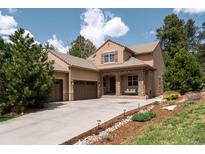 Inviting single-Gathering home featuring a stone archway, porch swing, 3-car garage, and tile roof at 5091 Hidden Pond Pl, Castle Rock, CO 80108