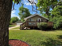 Charming single-story home featuring a welcoming front porch and lush green lawn with mature trees at 9075 W 66Th Ave, Arvada, CO 80004