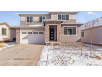 Beautiful two-story home featuring stone accents, a two-car garage, and neutral color palette at 9122 Telluride Ct, Commerce City, CO 80022