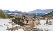 Stunning mountain home featuring stone accents, a three-car garage, and breathtaking snowy mountain views at 174 Sage Dr, Breckenridge, CO 80424