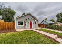 Gray house with red door, landscaped yard, and walkway at 725 Osceola St, Denver, CO 80204