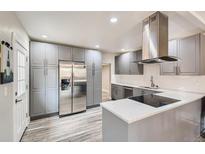 Bright kitchen featuring stainless steel appliances, gray cabinets, and wood-look flooring at 725 Osceola St, Denver, CO 80204