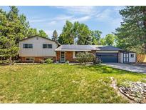 Charming two-story home with brick and siding exterior, solar panels, and a well-manicured lawn at 12475 W 38Th Ave, Wheat Ridge, CO 80033