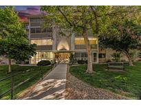 Exterior view of a multi-story apartment building with well-maintained lawns and mature trees at 3144 S Wheeling Way # 106, Aurora, CO 80014
