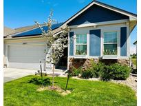 Charming home featuring a well-manicured lawn, solar panels, window boxes, and a two-car garage at 6805 Zebra Grass Ln, Parker, CO 80138