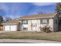 Brick ranch home with attached two-car garage and landscaped lawn at 1536 S Wright Ct, Lakewood, CO 80228