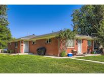 Charming brick duplex with a well-maintained lawn and mature trees under a clear blue sky at 2495 S Race St, Denver, CO 80210